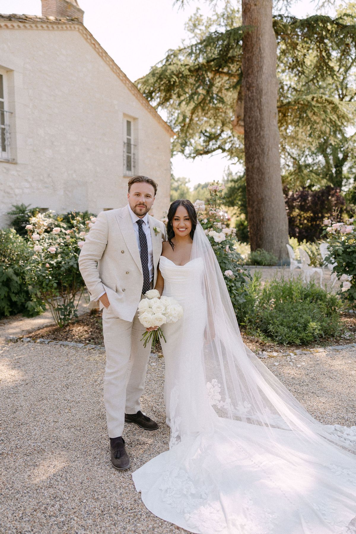 Bride and groom walking together through the rose garden