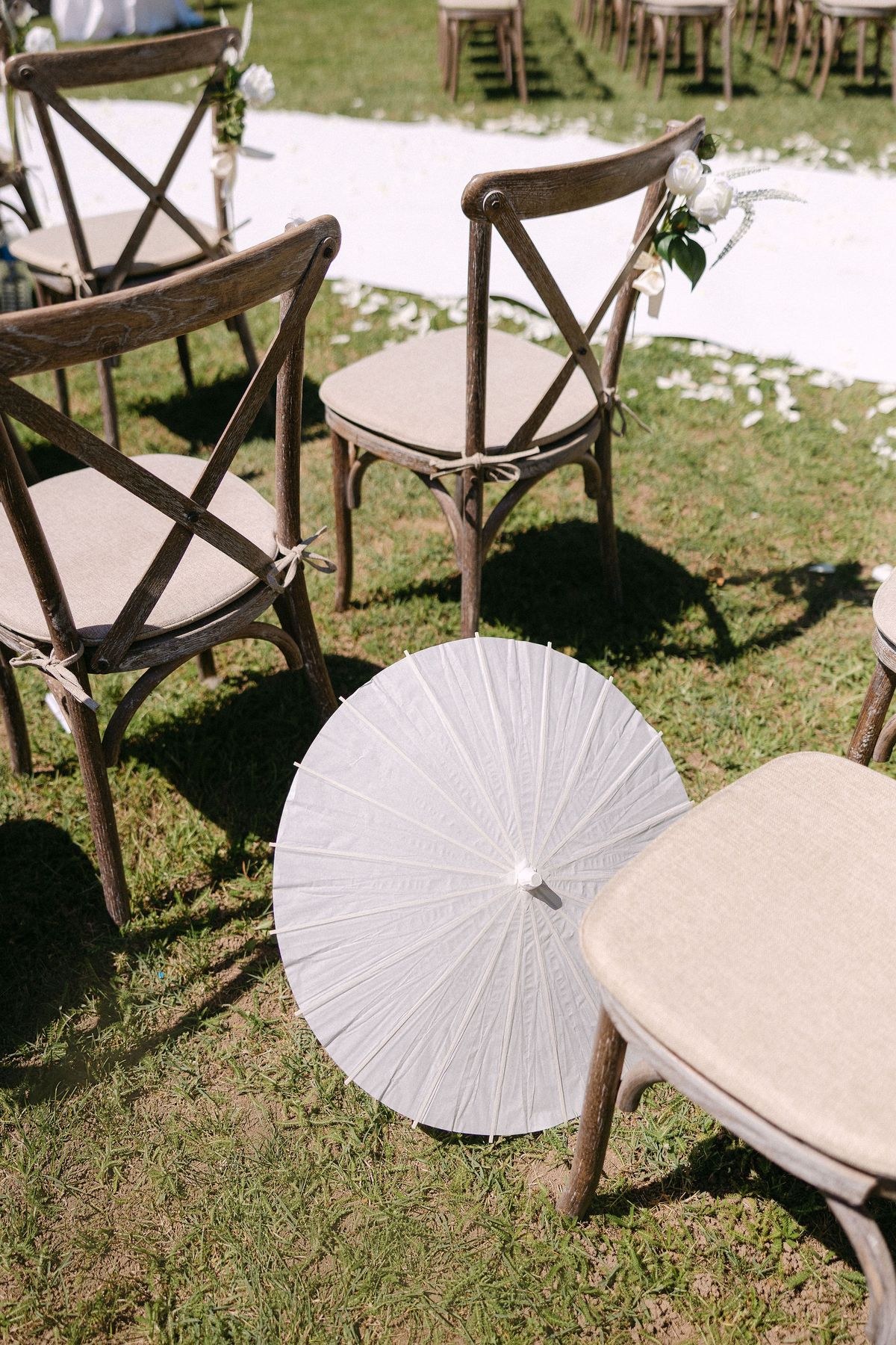 White parasol resting on a cross-back ceremony chair