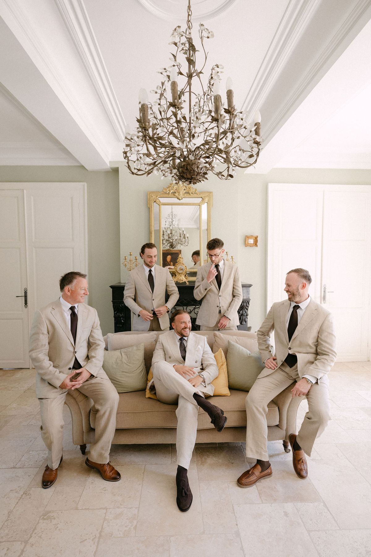 Groomsmen in cream suits getting ready together