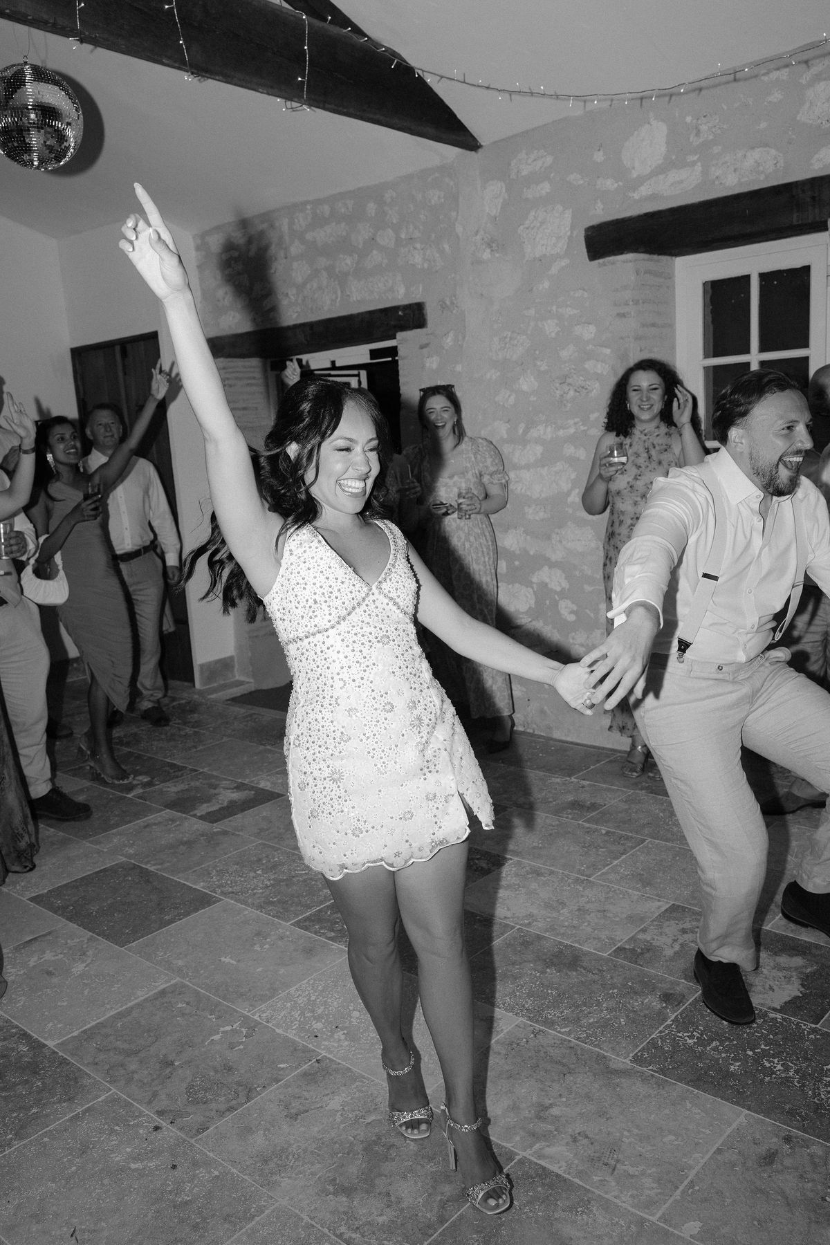 Black and white shot of a guest dancing at the reception