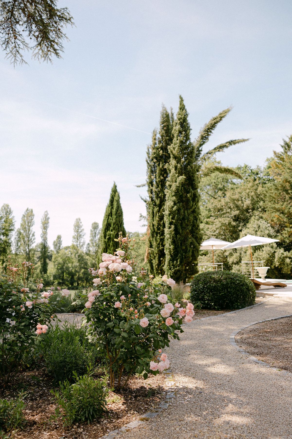 Rose-lined garden path and outdoor seating at Château Lacanaud