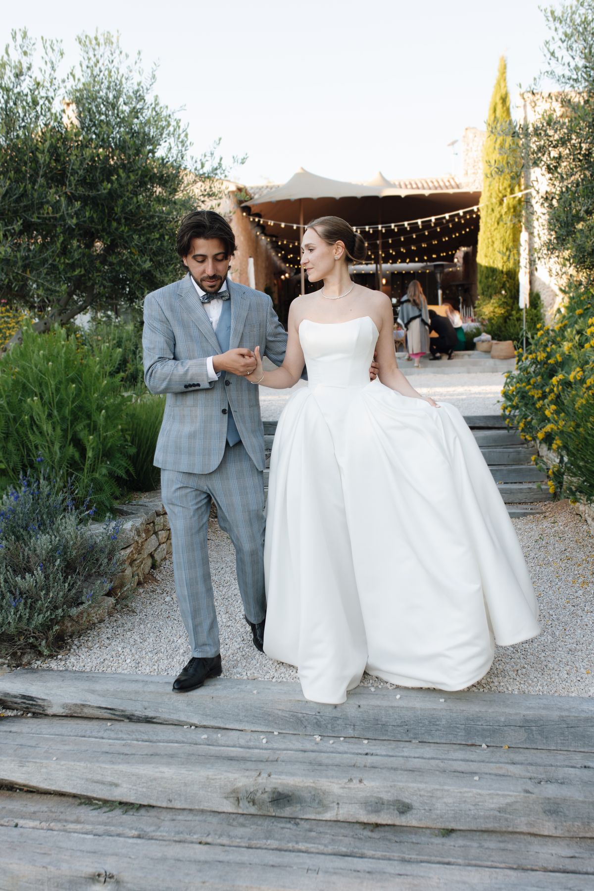Bride and groom holding hands on the venue steps