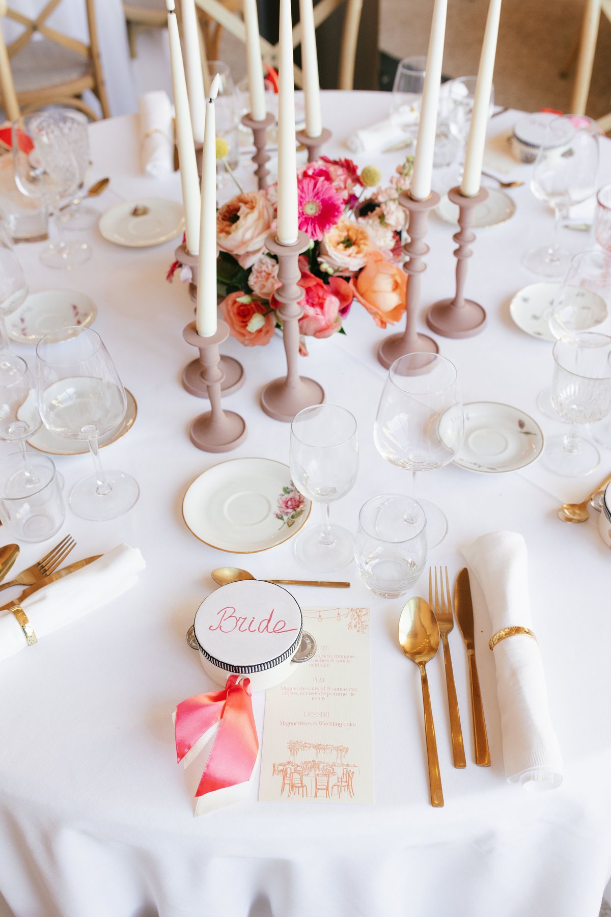 Reception table setting with pink florals and a bride's place card