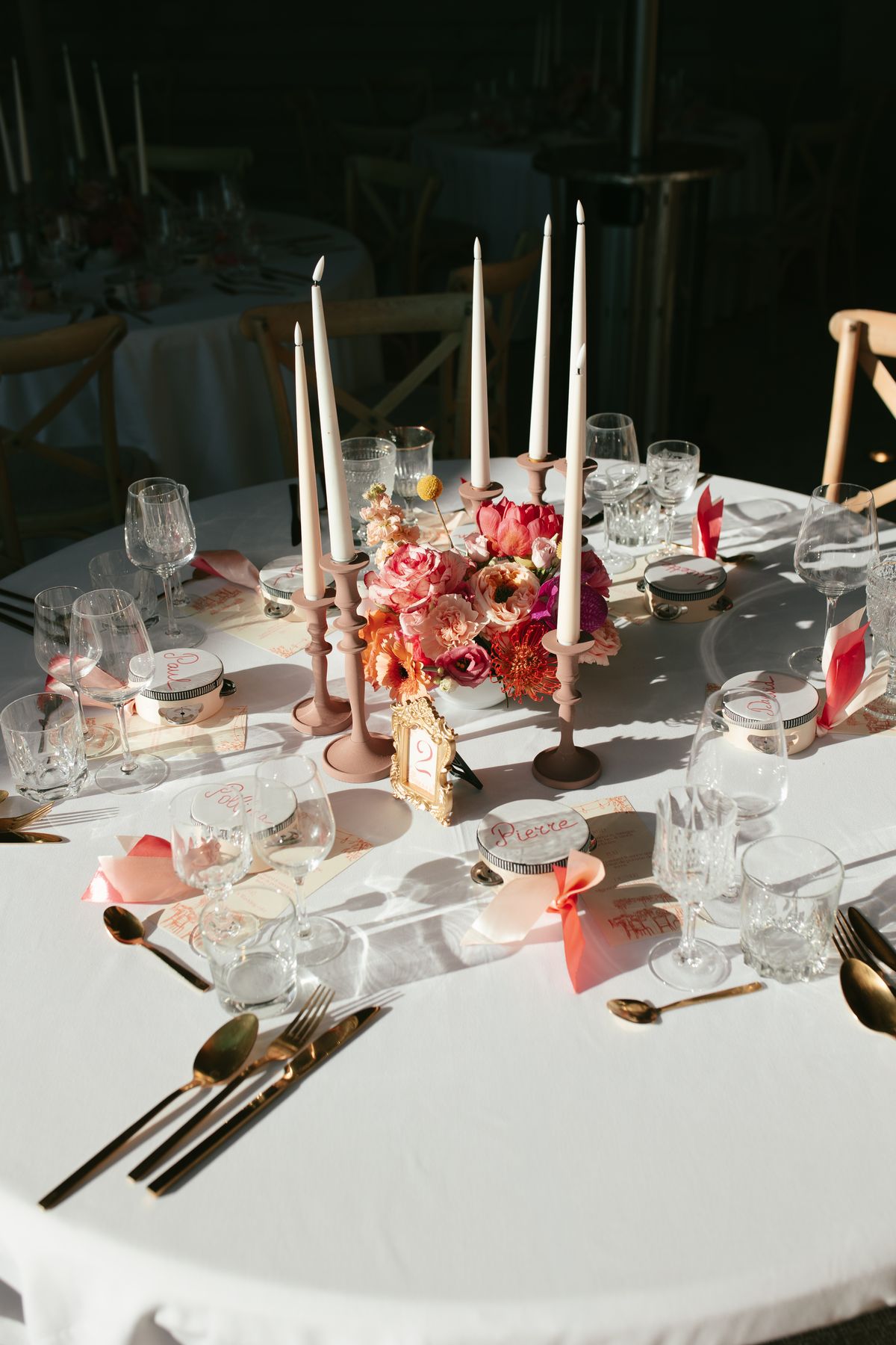 Reception table setting with burgundy and pink florals at dusk