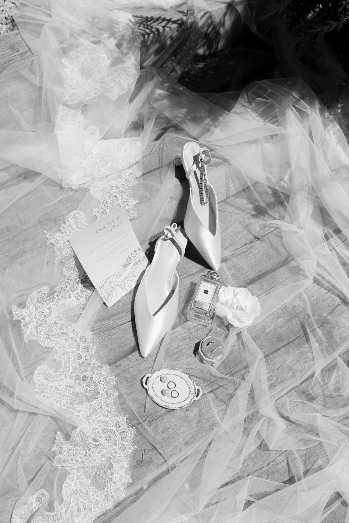 Bride's shoes and jewellery styled on lace, black and white