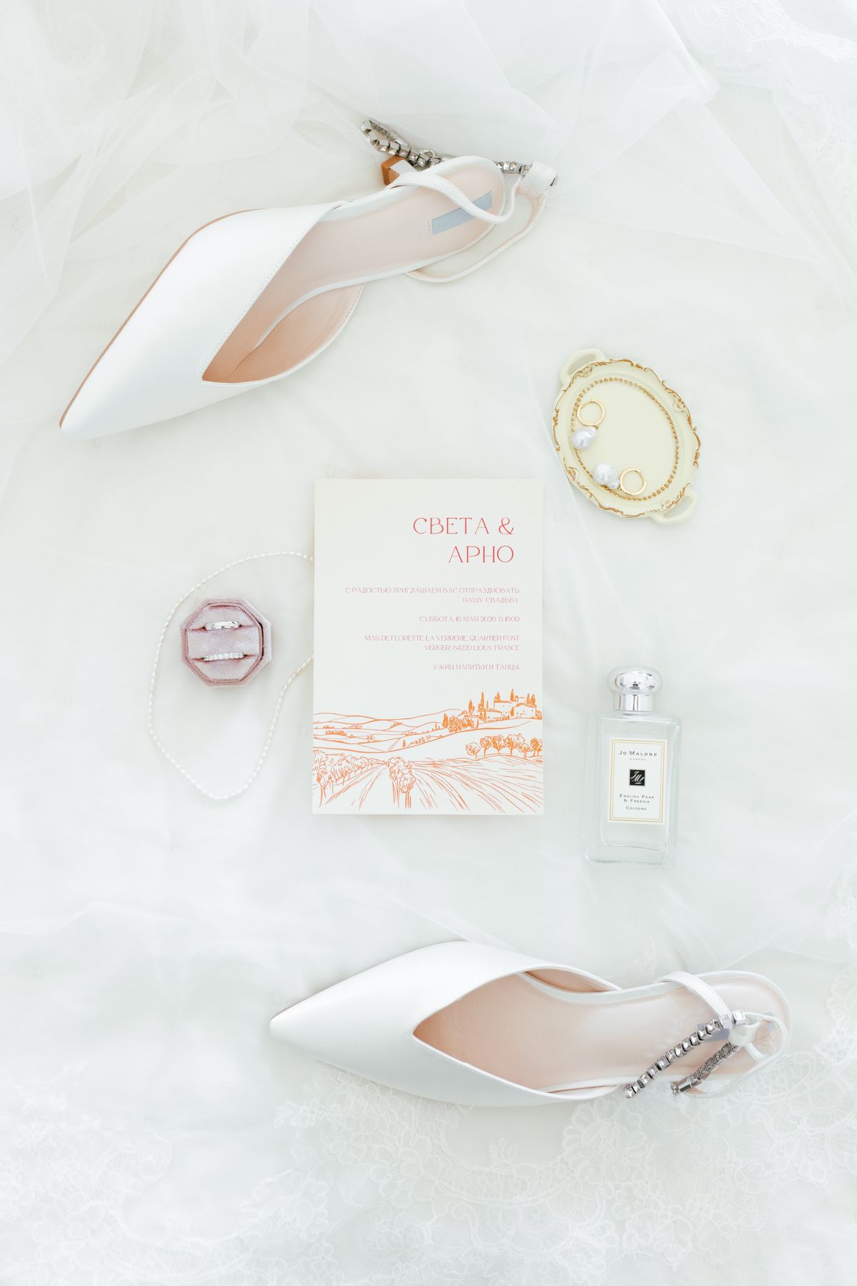 Wedding invitation with rings and perfume styled as a flat lay