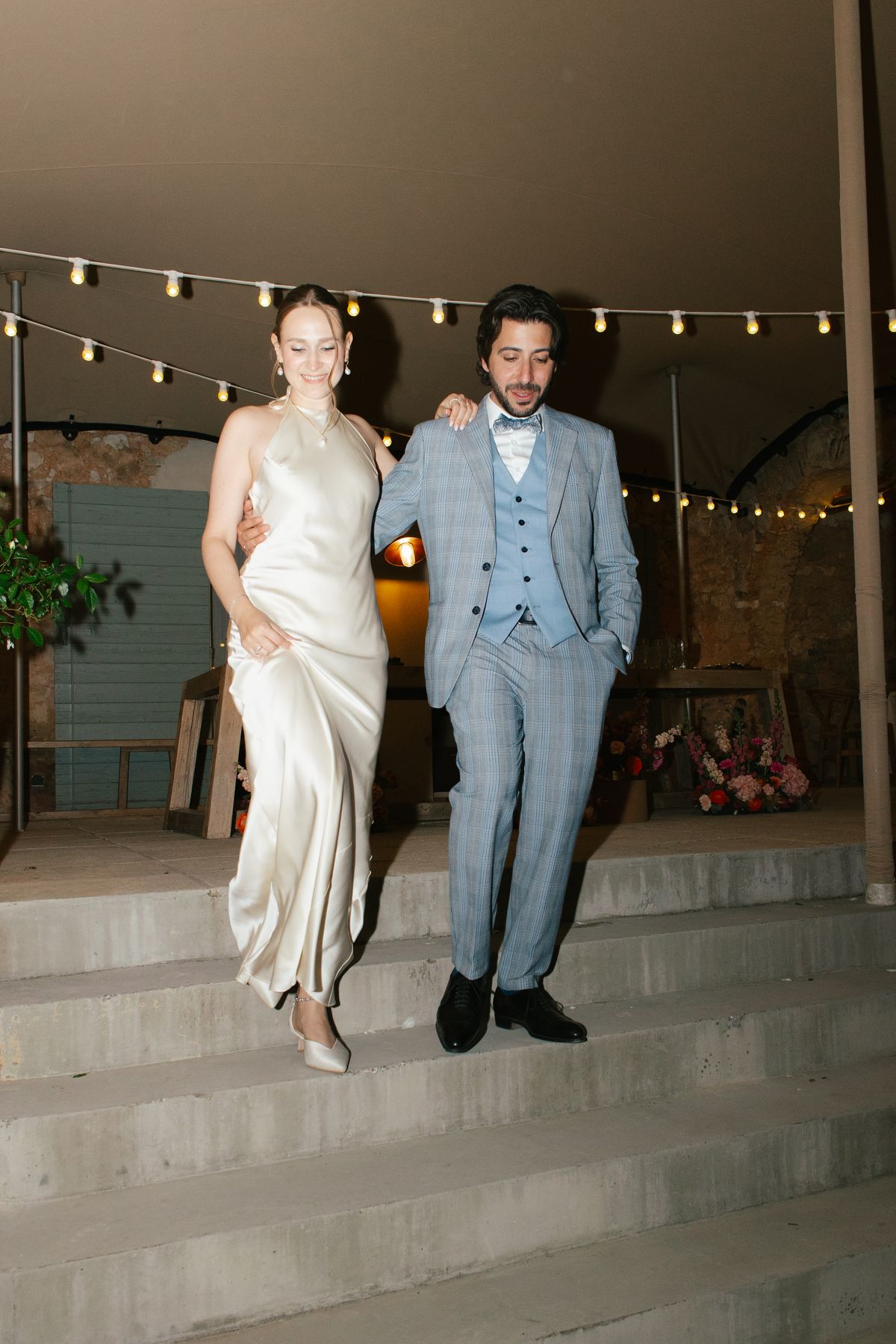 Bride and groom walking arm in arm at the reception