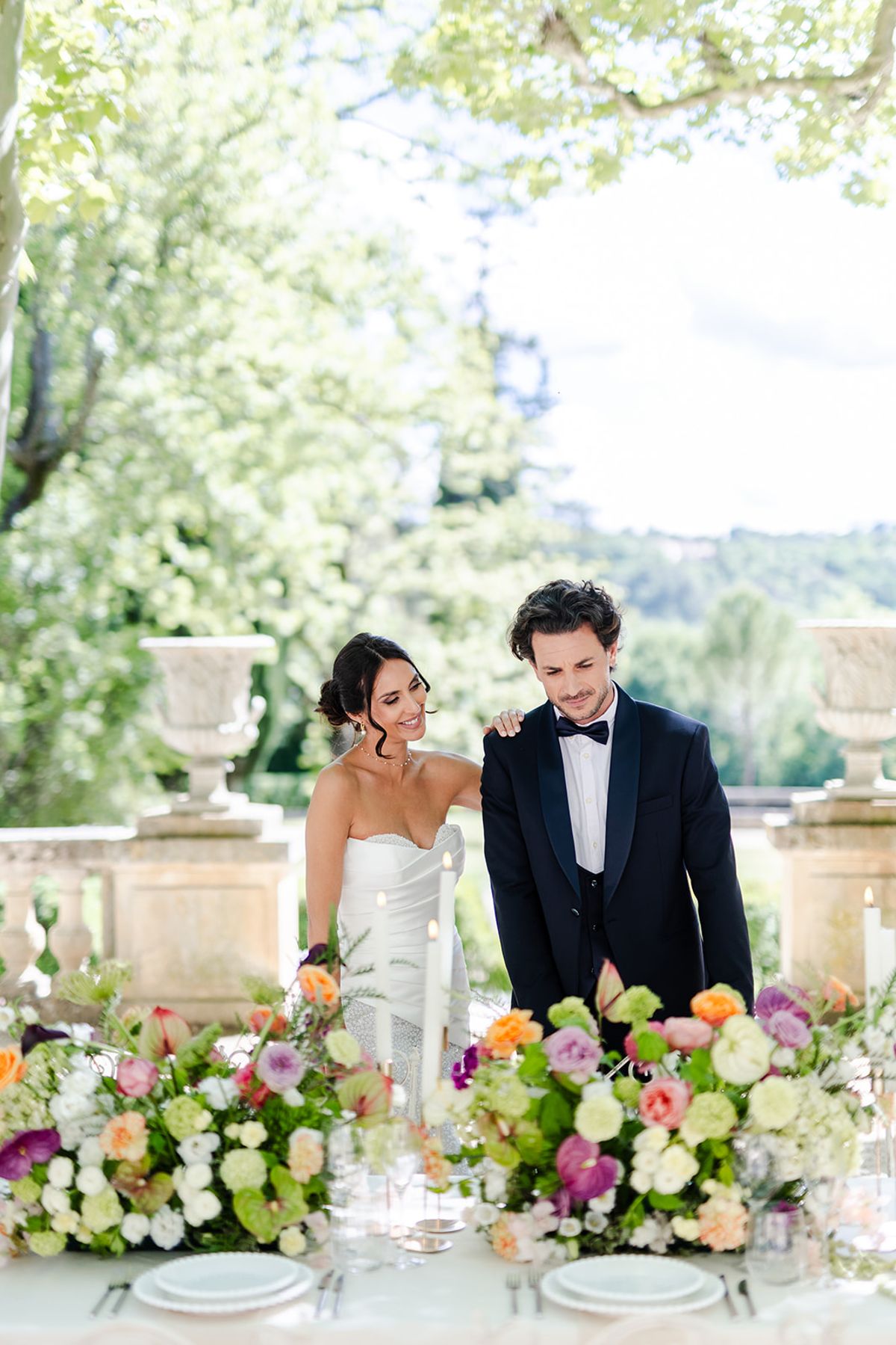 Couple standing at the dinner table behind the floral arrangements