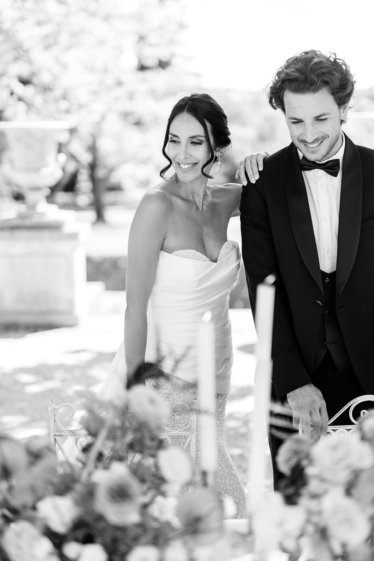 Couple laughing at the dinner table beside taper candles, black and white