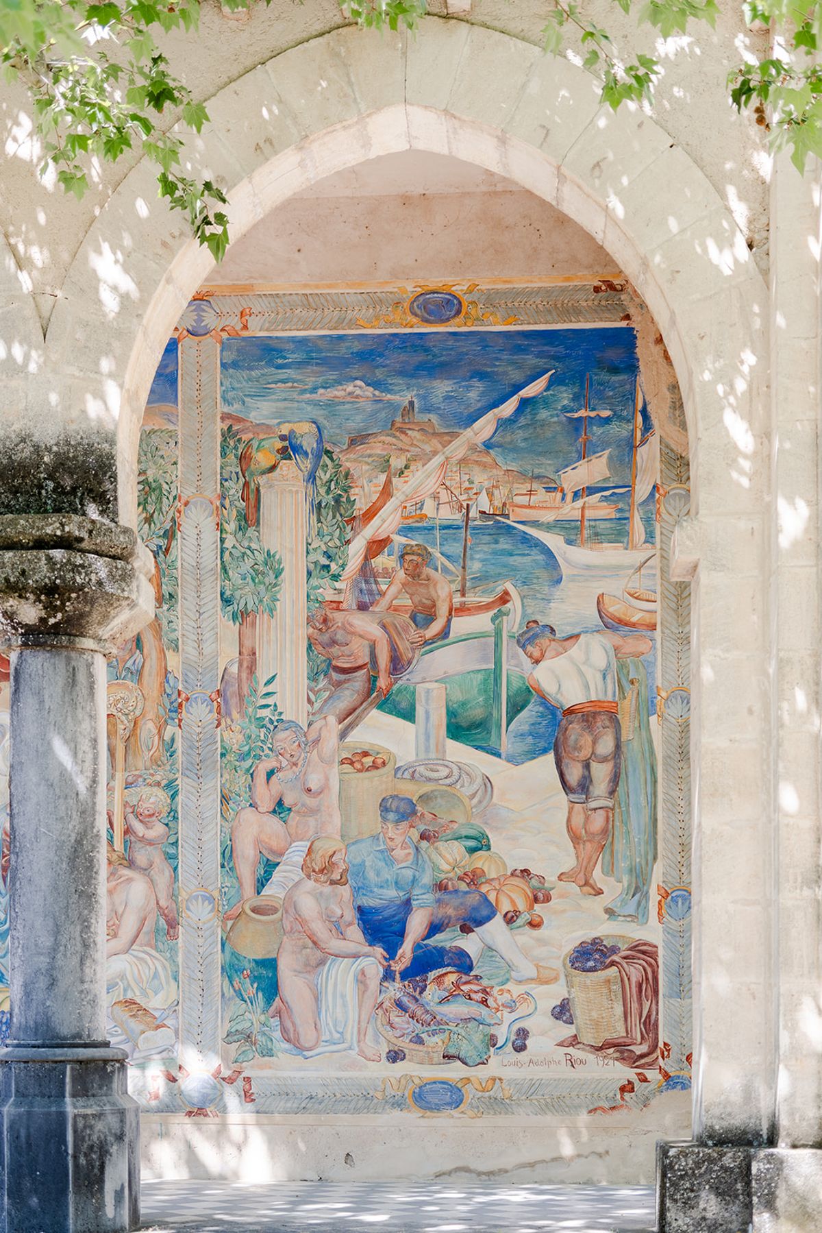 Painted fresco of bathers seen through a stone arch at Château de Pradines