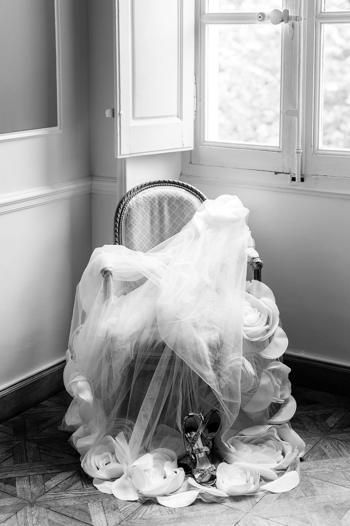 Tulle veil draped over a Louis-style chair in a panelled salon, black and white