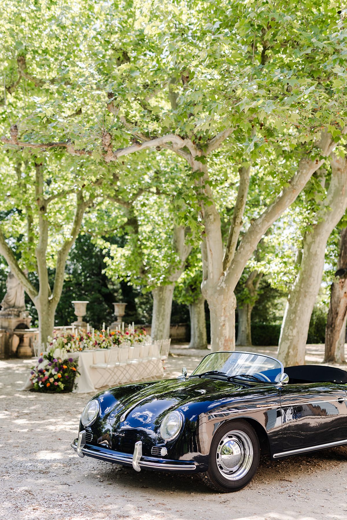 Dark blue vintage convertible parked under the plane trees at Château de Pradines