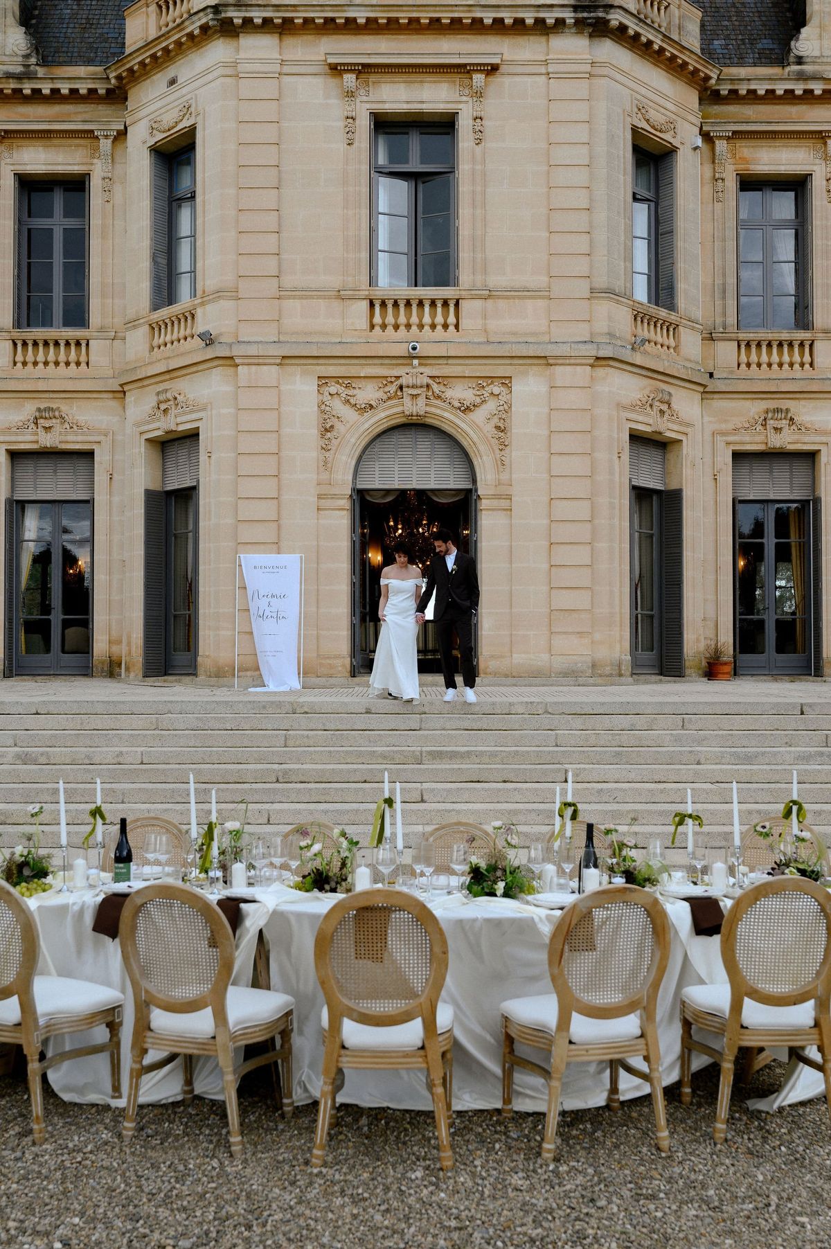 Couple in the doorway of Château du Terral above a long banquet table on the steps