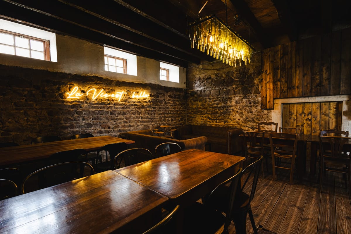 Felix Bar with a wine-bottle chandelier, leather sofas and a neon sign reading La Vie est Belle