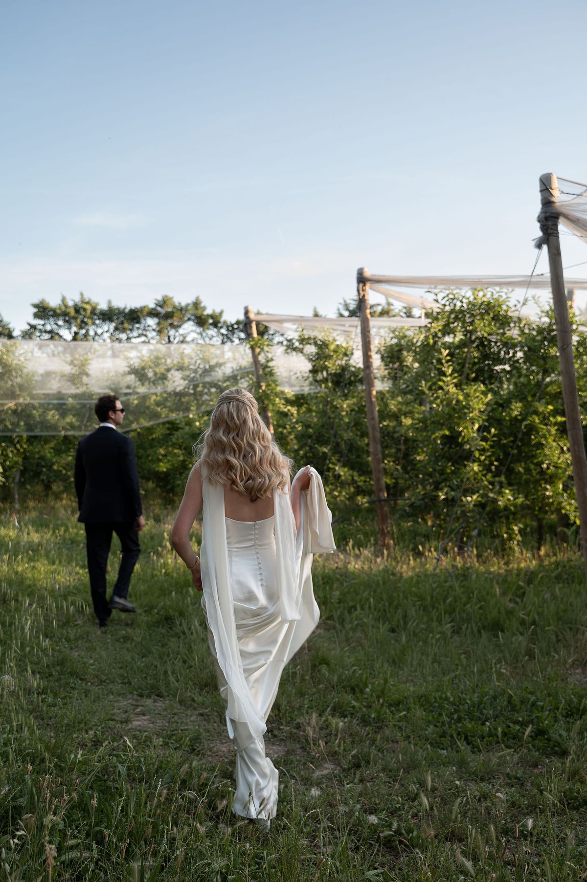 Louise in her silk gown walking through the orchard in the evening light