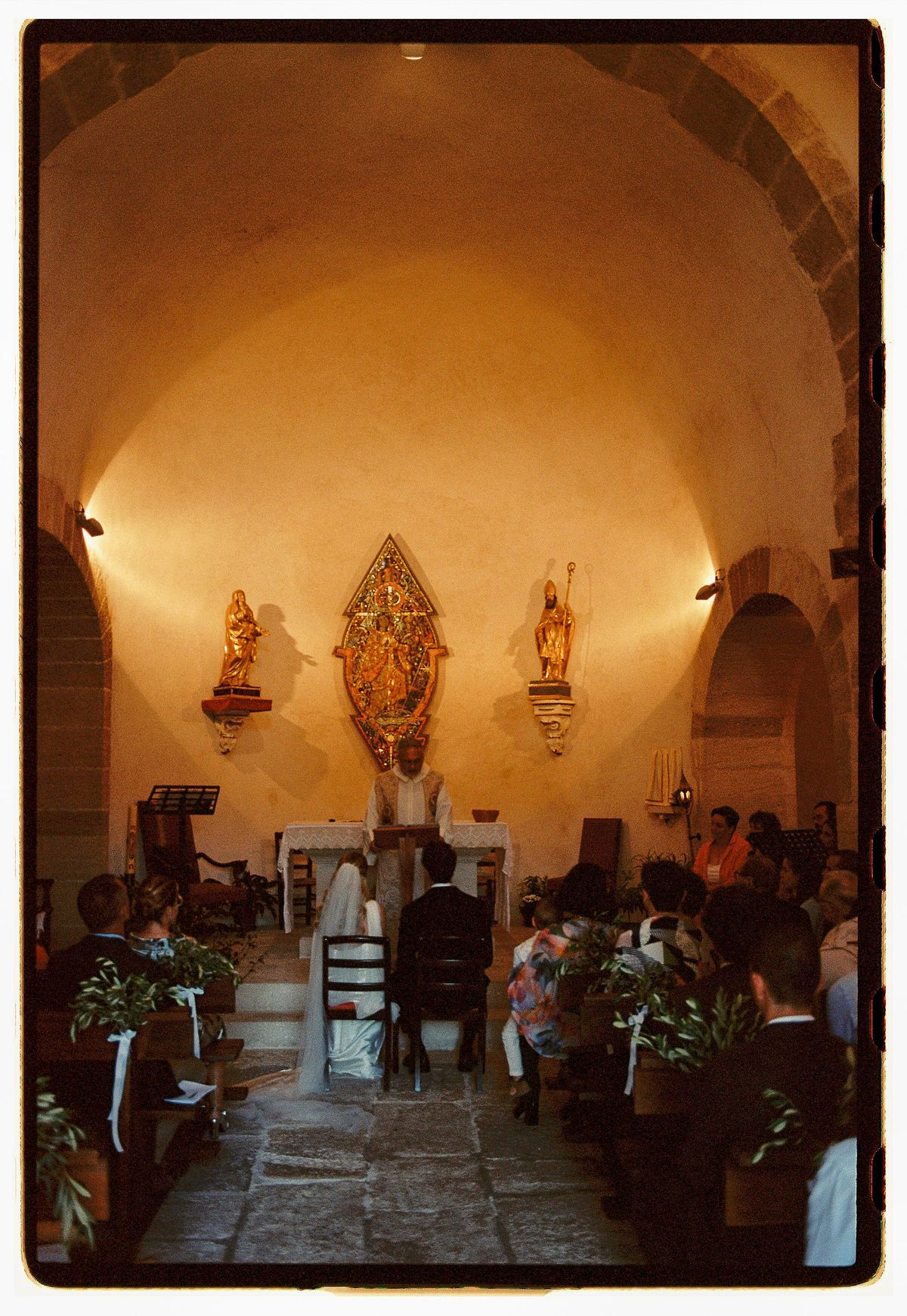 The interior of the hilltop village church with olive branch arrangements, photographed on film