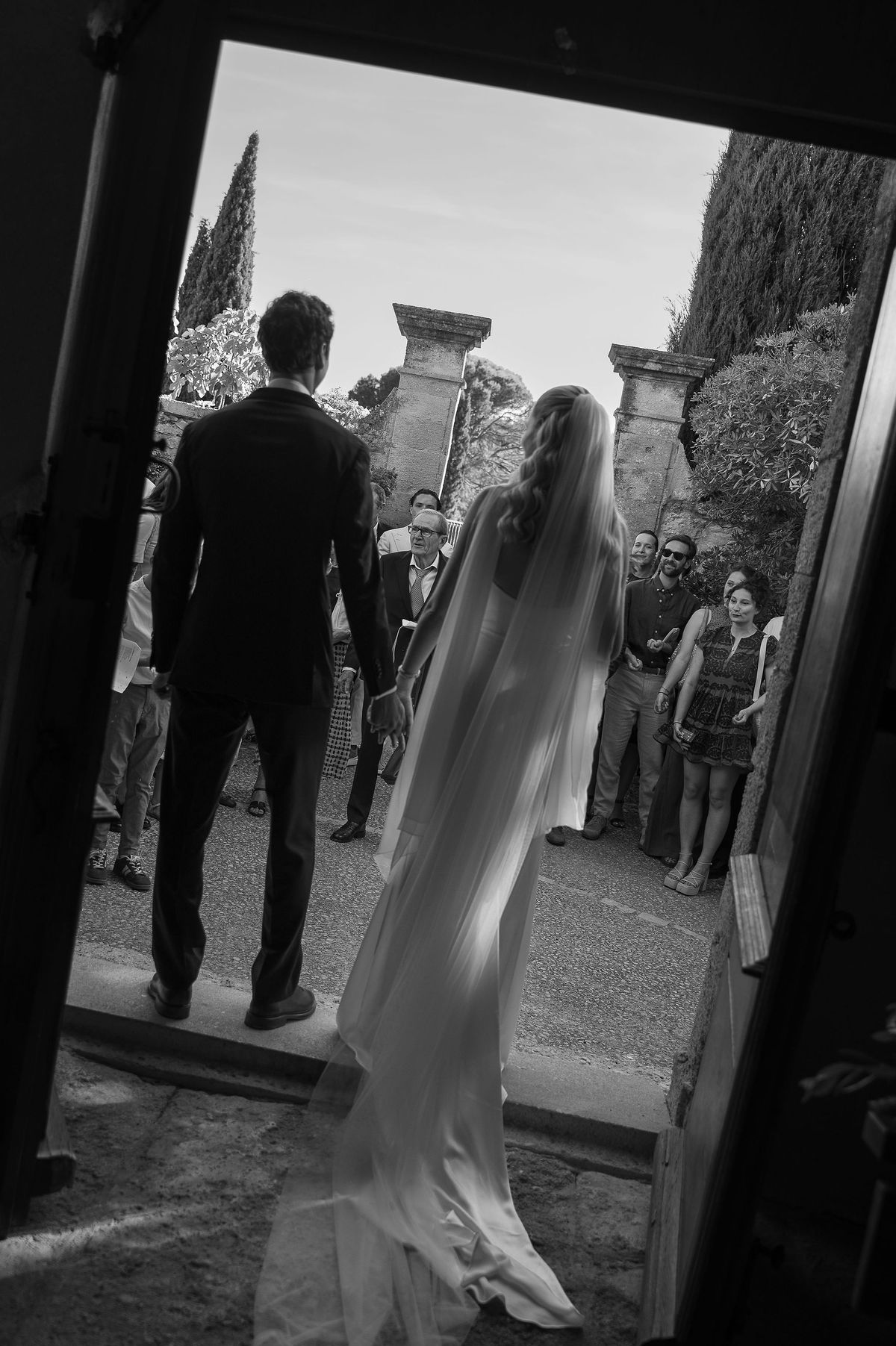 Black and white photograph of Louise and Lucas leaving the church through the stone doorway