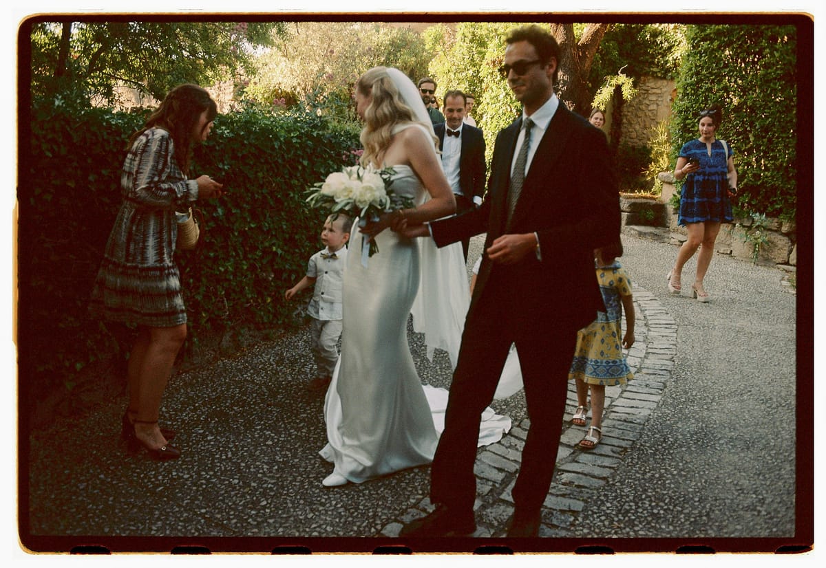 Louise and Lucas walking through the village with their guests, photographed on film