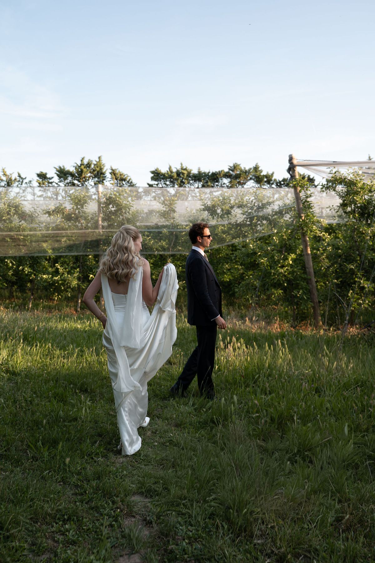 Louise and Lucas walking through the orchard in the evening light