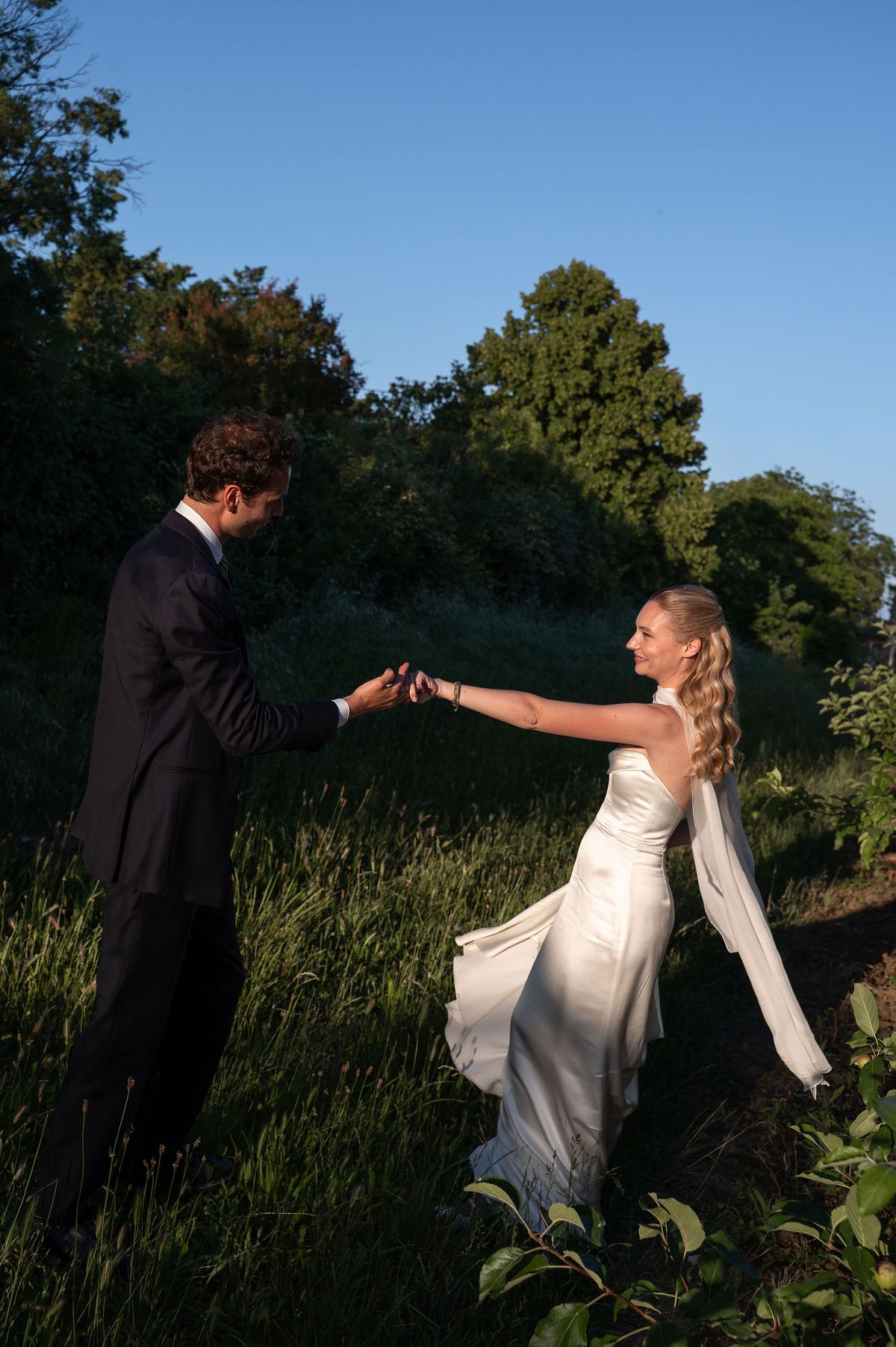 Louise and Lucas turning together in the orchard in the evening light