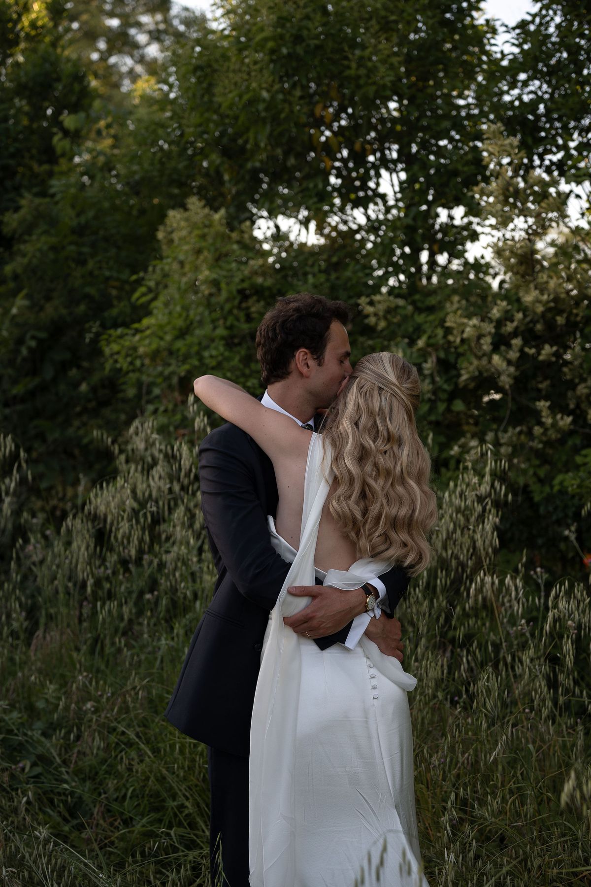 Louise and Lucas embracing among the trees at the close of the day