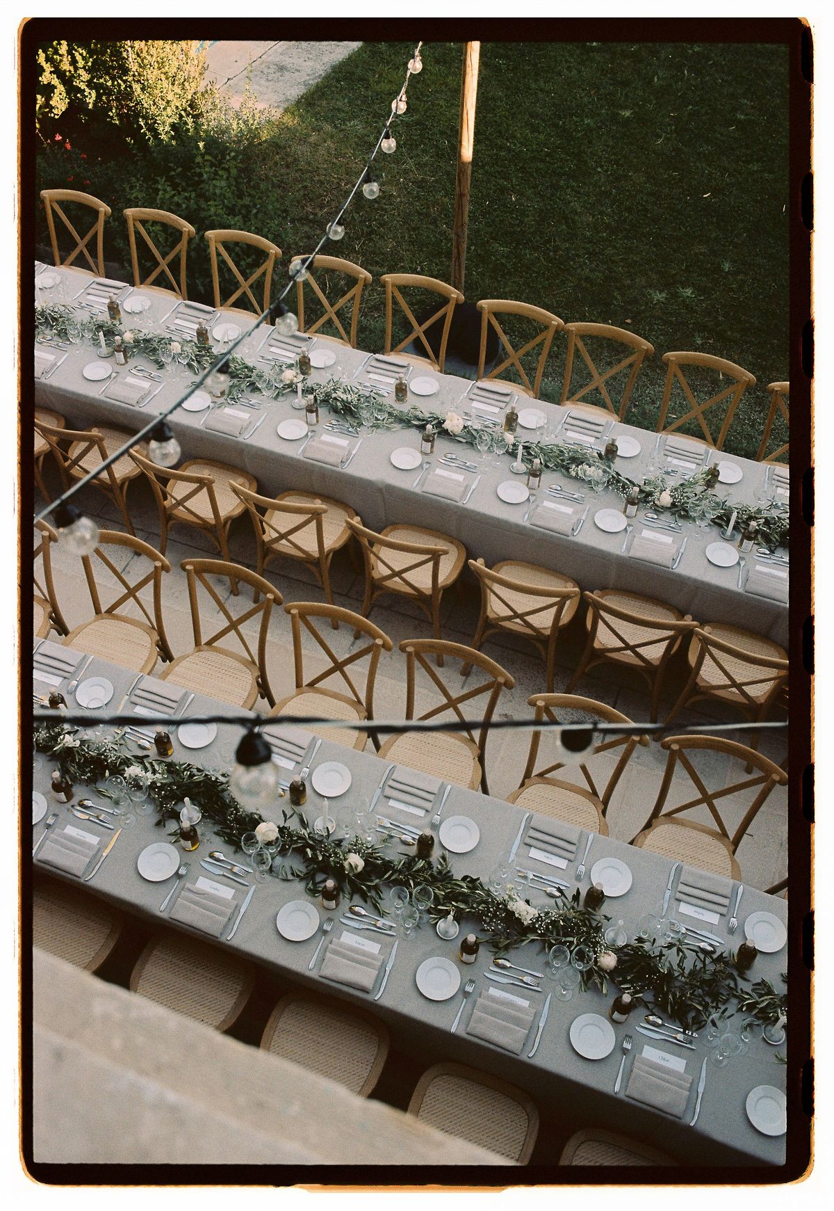 The long reception table set with candles and olive branches, photographed on film from above