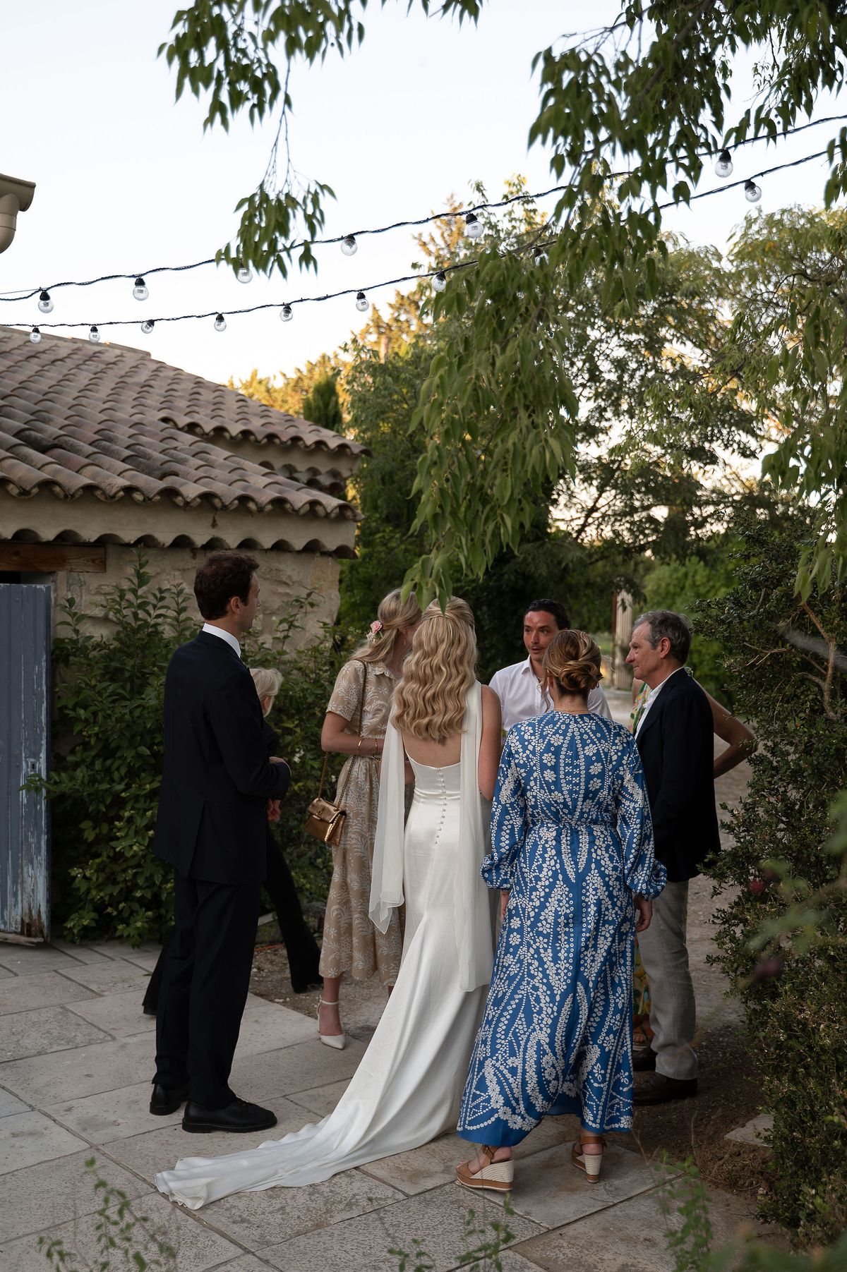 Louise talking with guests in the garden during the evening reception