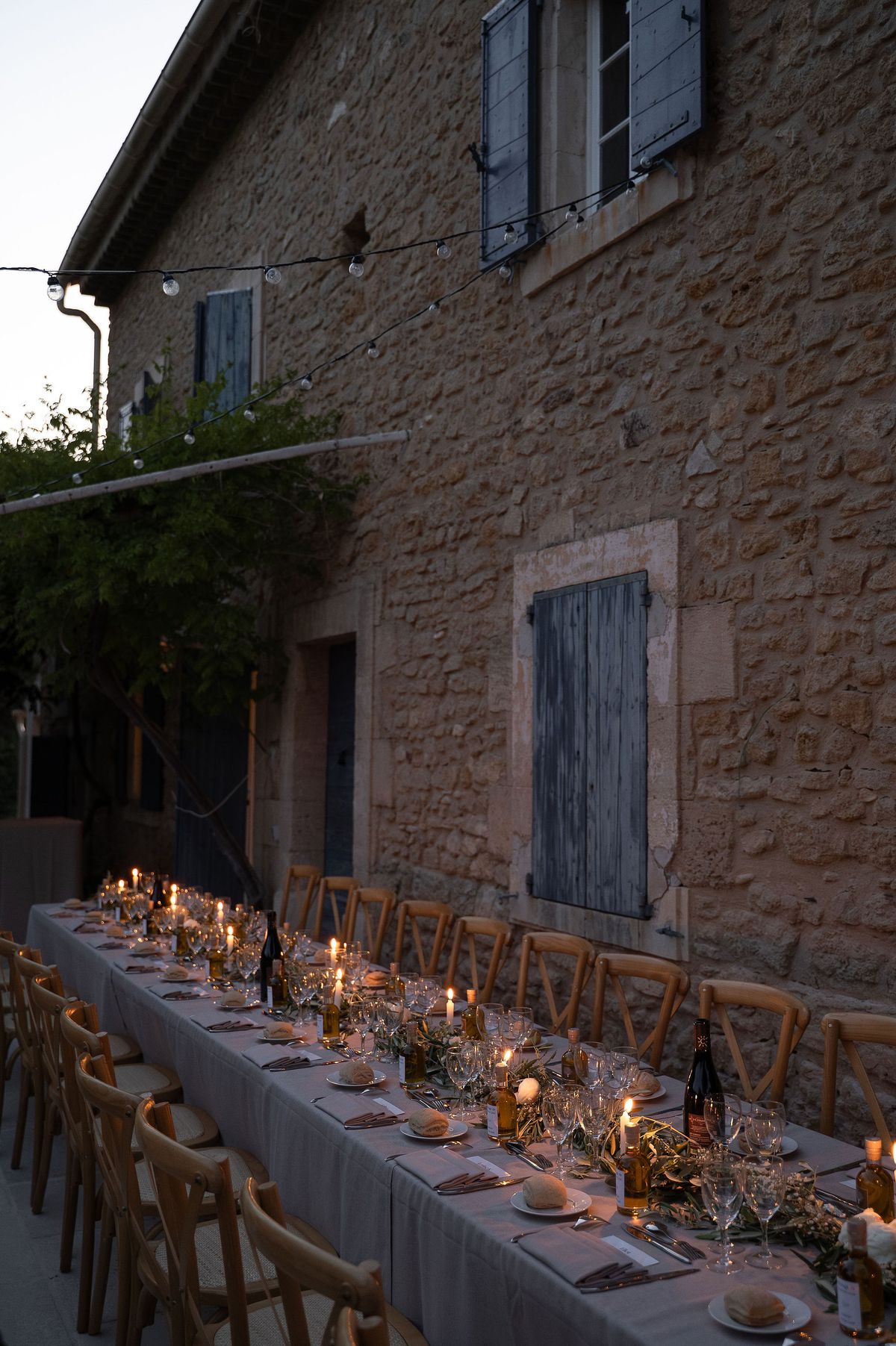 The reception table lit with candles against the stone facade at nightfall