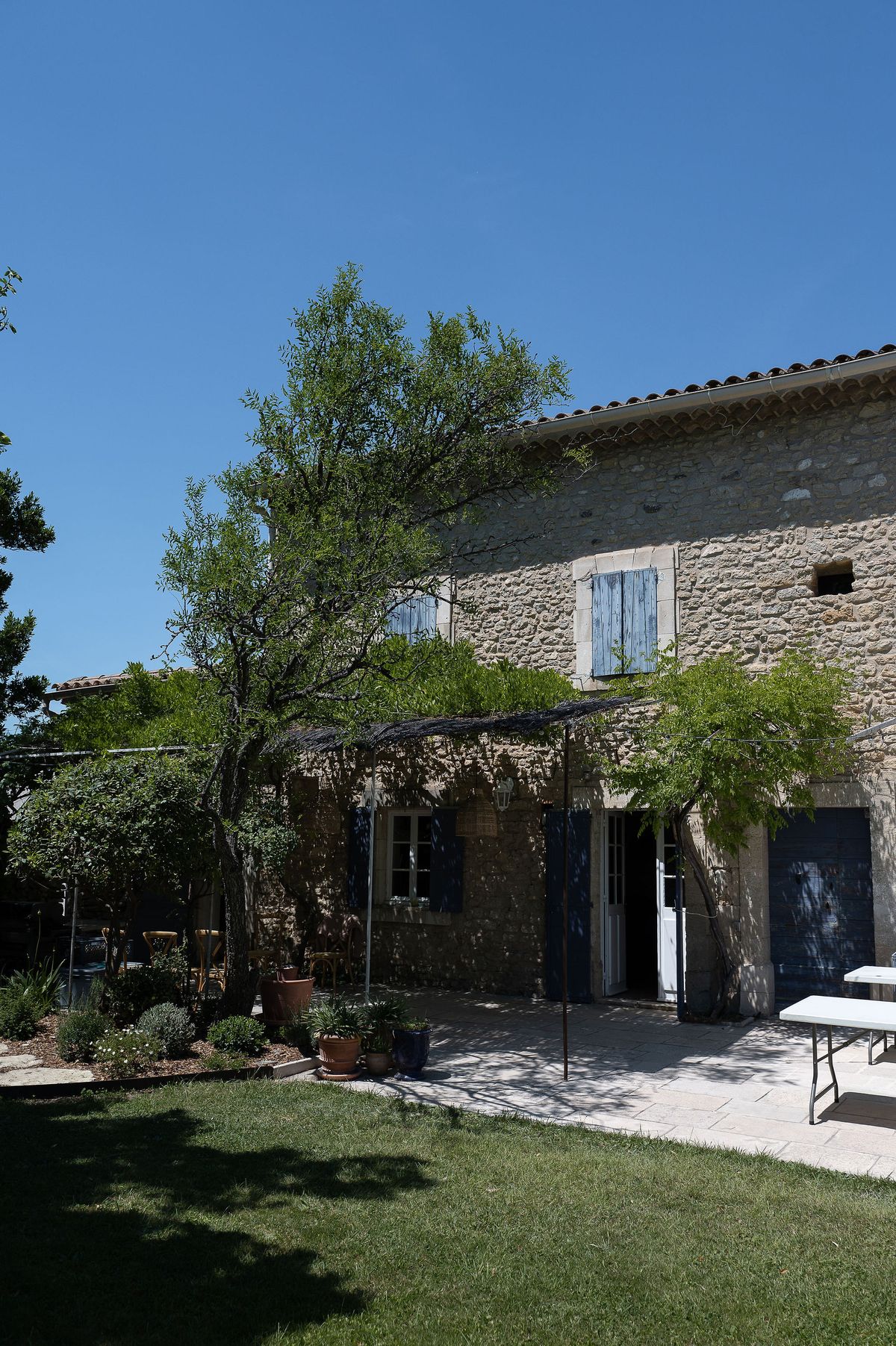 The stone family home with pale blue shutters where Louise and Lucas held their spring wedding reception in the Luberon