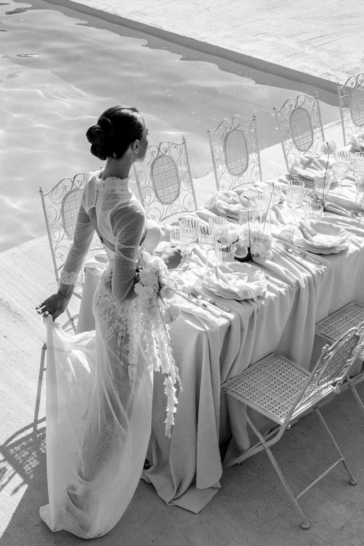 Black and white portrait of the bride standing at the reception table