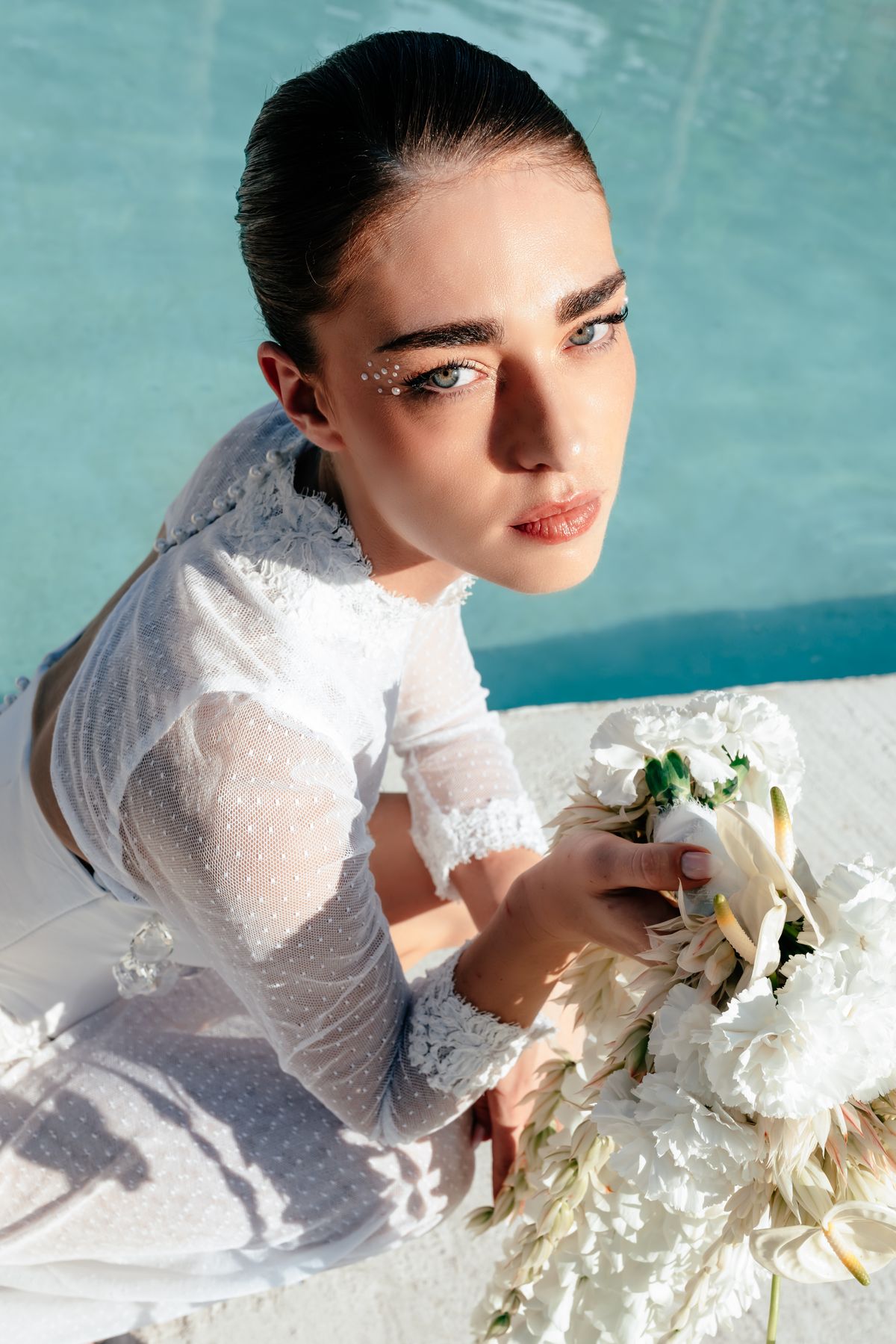 Close portrait of the bride holding white anthurium and ranunculus