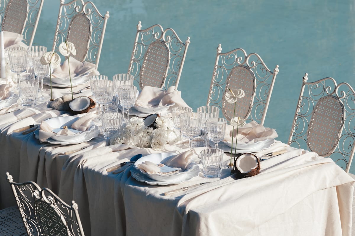 View along the dressed reception table with wrought iron chairs