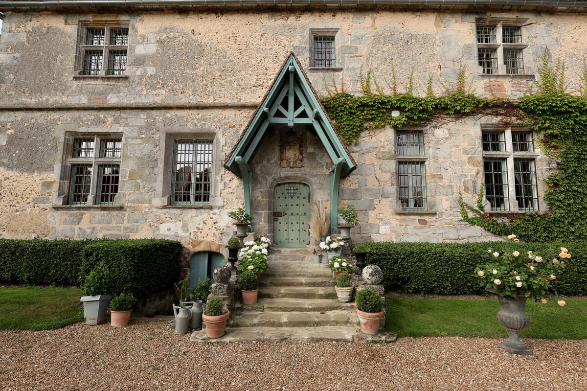 Entrance steps to the manor's front door, flanked by potted topiary and hydrangeas