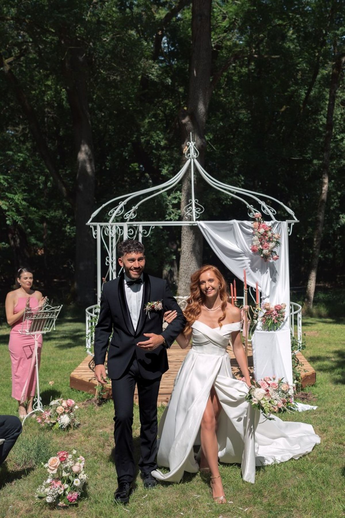 Blush and fuchsia styled shoot at Château du Causse, Occitanie, the couple walking away from the gazebo after the ceremony
