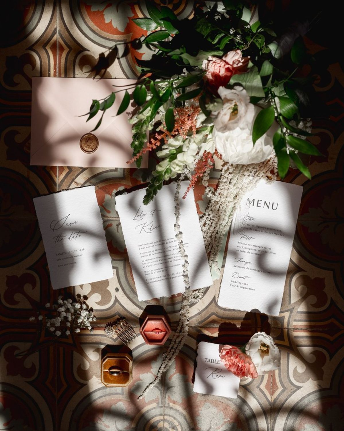 Blush and fuchsia styled shoot at Château du Causse, Occitanie, deckle-edged stationery, a blush envelope with a gold wax seal, rings and flowers