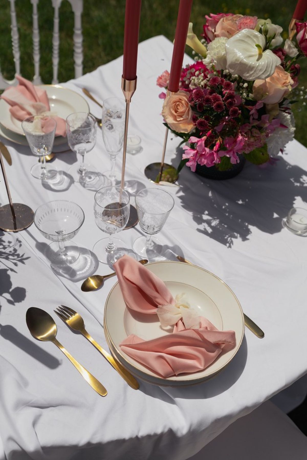 Blush and fuchsia styled shoot at Château du Causse, Occitanie, a place setting with a blush napkin, gold cutlery and crystal glasses