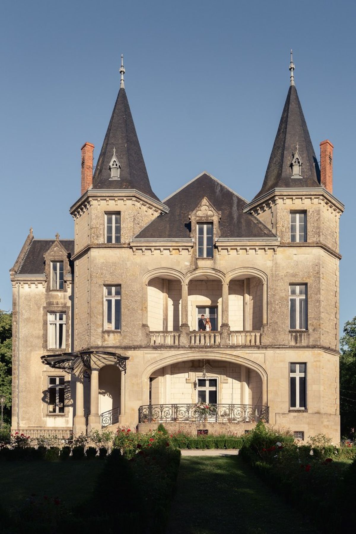 Blush and fuchsia styled shoot at Château du Causse, Occitanie, the stone façade and turrets of Château du Causse
