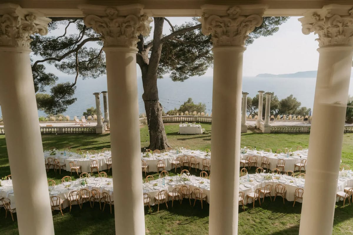 Aerial view of a garden ceremony with guests and the sea beyond at Domaine Rocabella, French Riviera