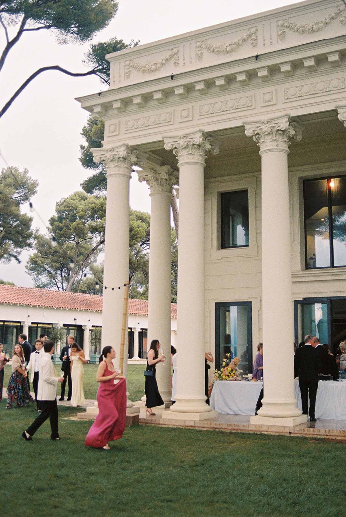 Guests at the cocktail hour on the lawn by the colonnaded pavilion at Domaine Rocabella, French Riviera