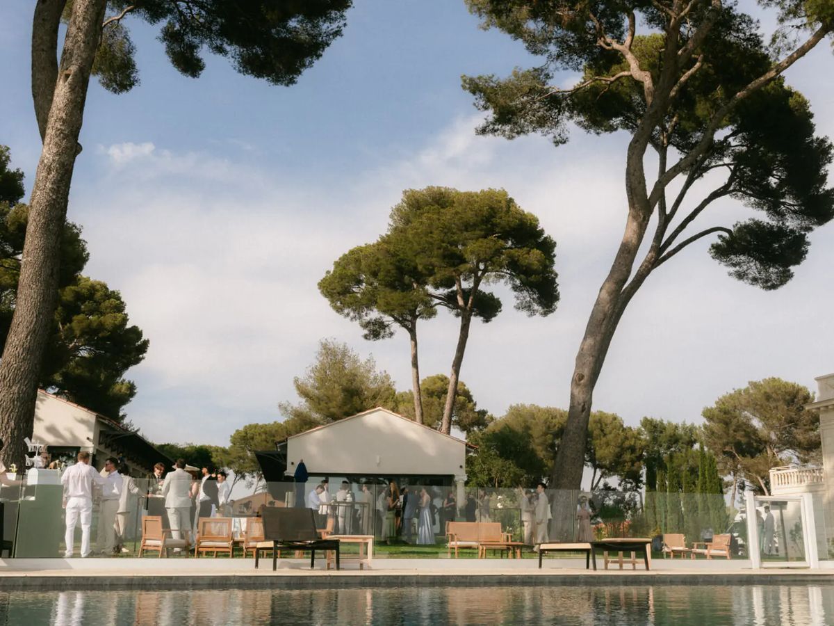 Dinner tables on the lawn seen between stone columns, with the sea beyond, at Domaine Rocabella, French Riviera