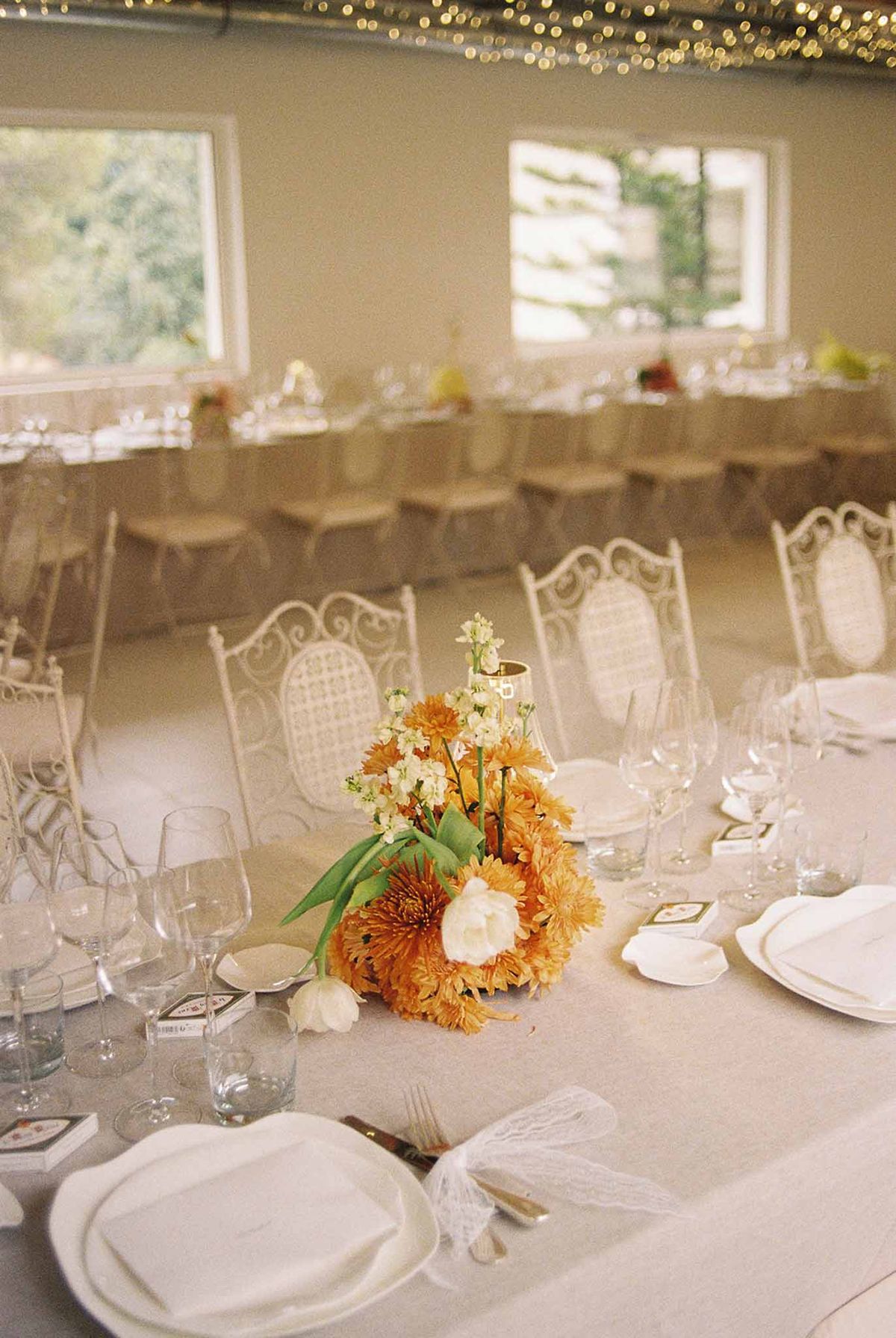 Orange flower centrepiece on a wedding dinner table at Domaine Rocabella, French Riviera