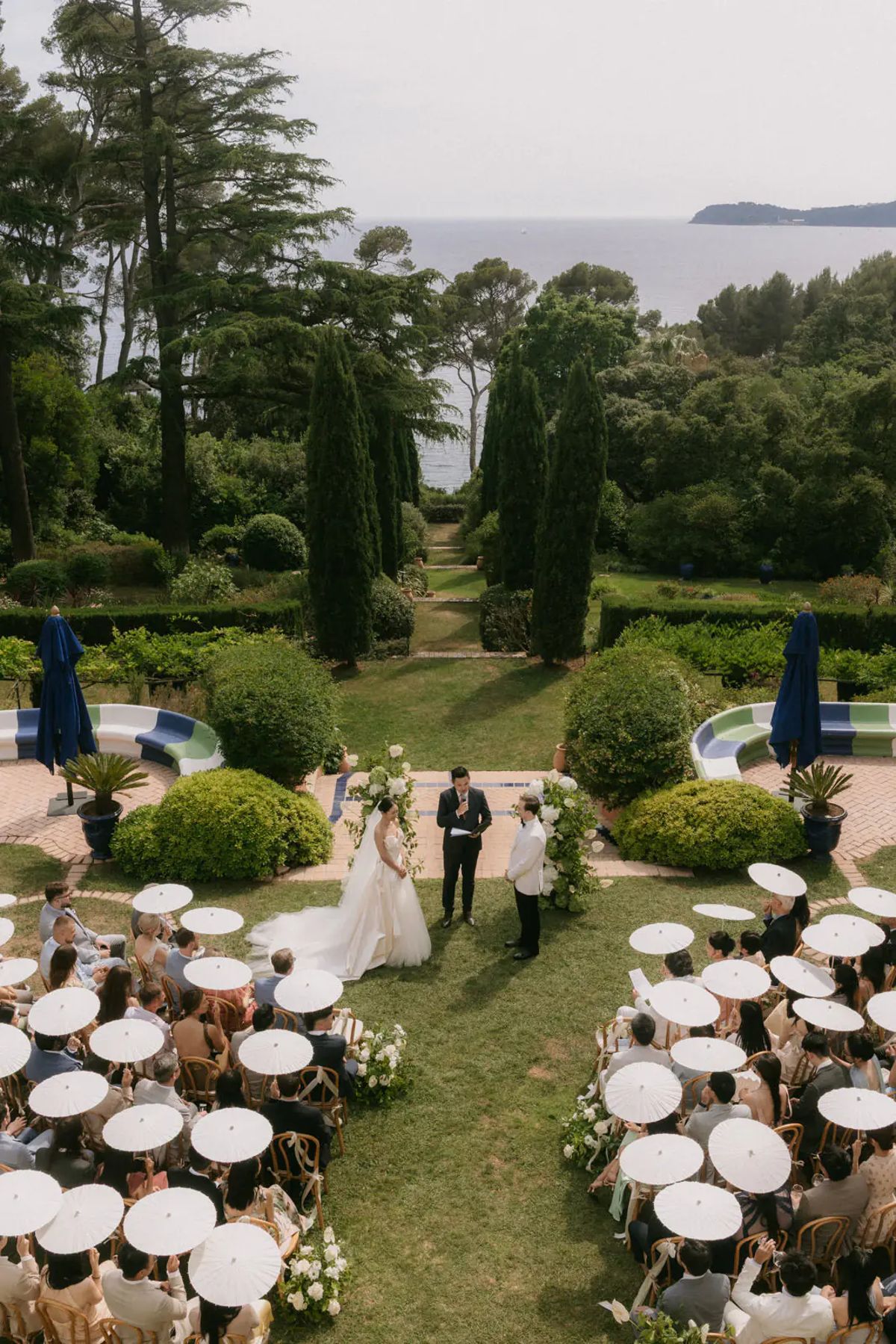 Round dinner tables set on the lawn beside the colonnaded pavilion at Domaine Rocabella, French Riviera