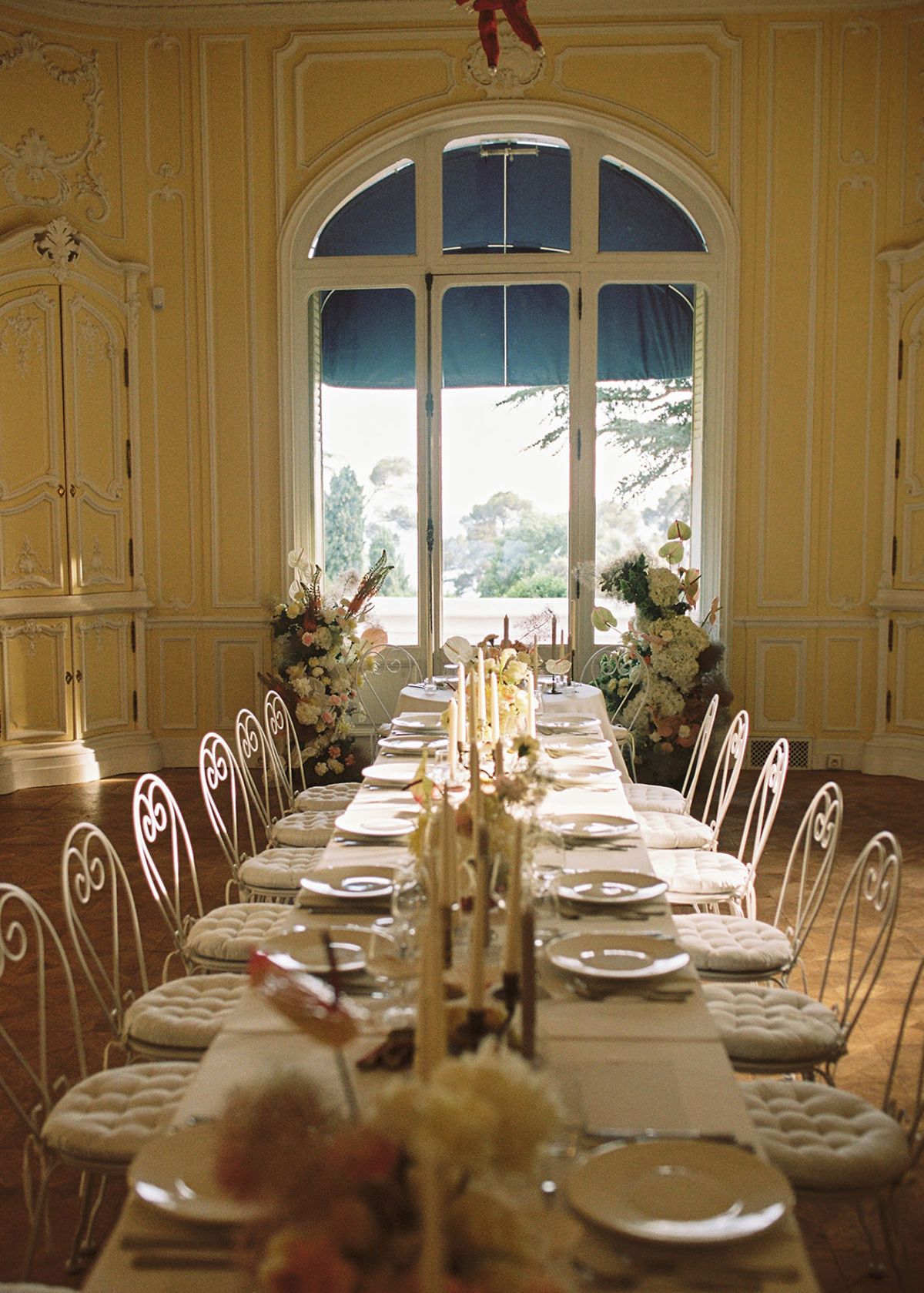 Long banquet table set for a wedding dinner in the yellow room at Domaine Rocabella, French Riviera