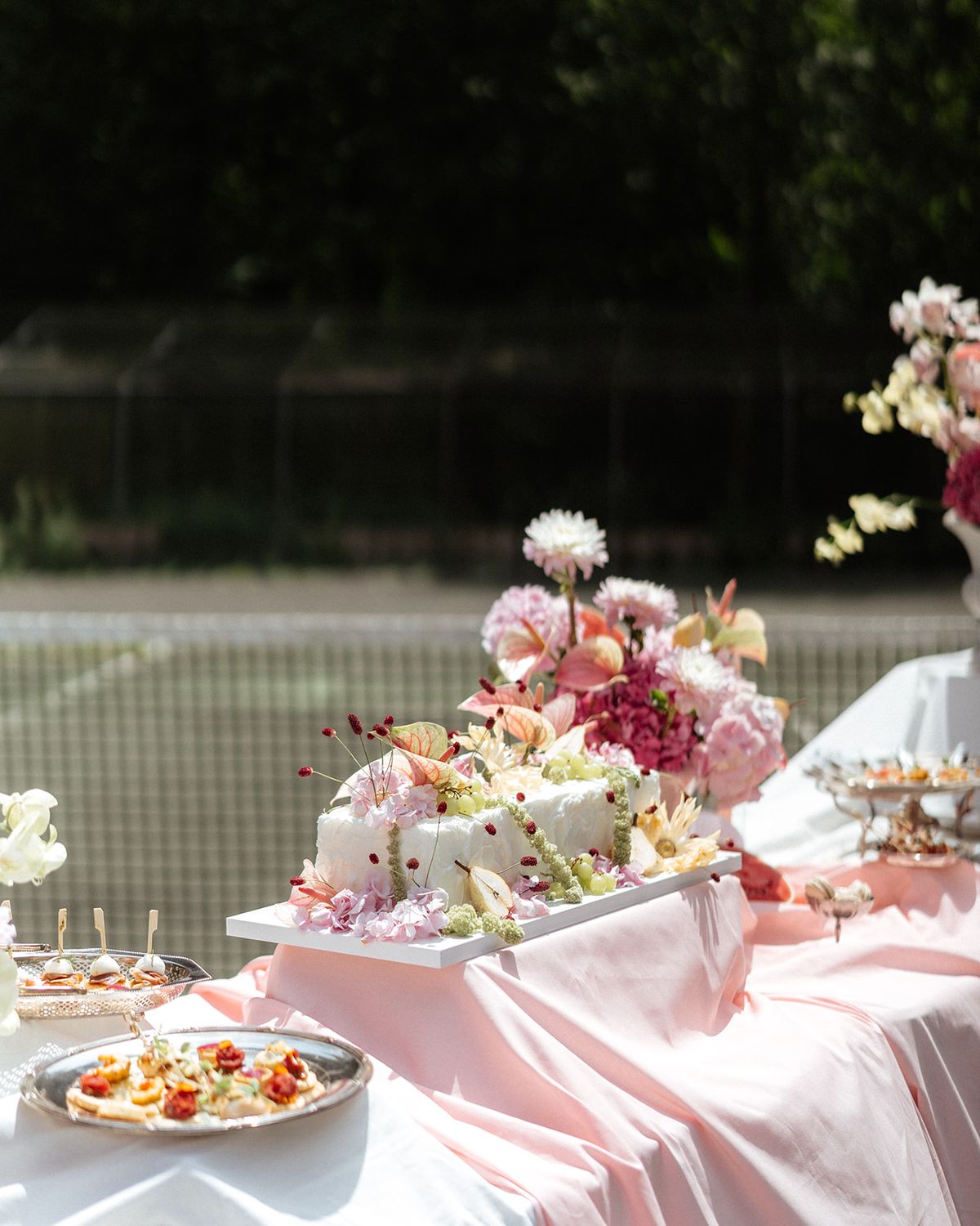 Cake and canapes on a draped table on the tennis court