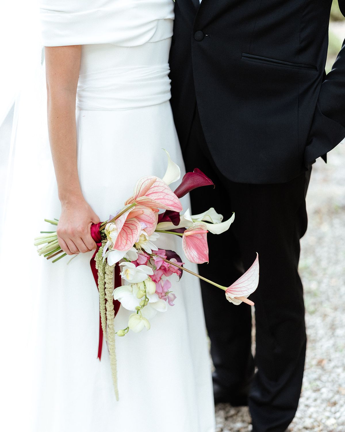 Bride holding her bouquet beside the groom in a black tuxedo