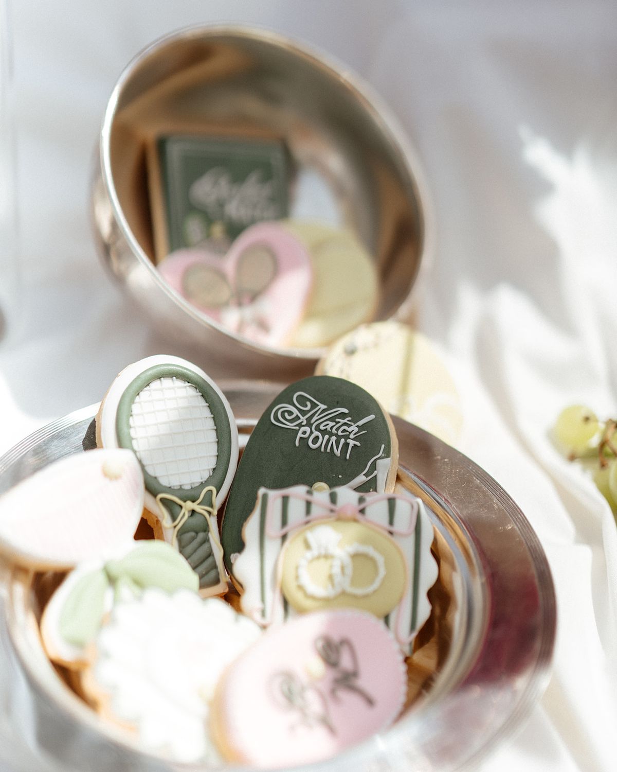 Silver dish of iced biscuits decorated with rackets and rings