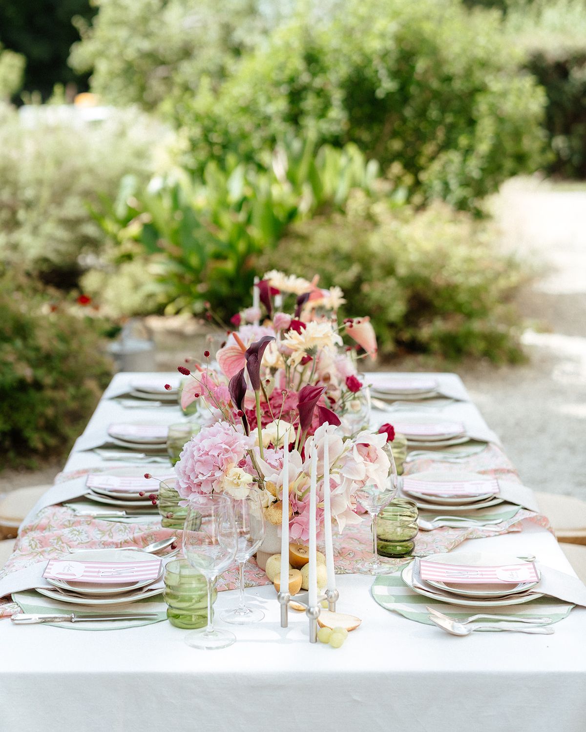 Table detail with deep pink flowers, green glassware and pears