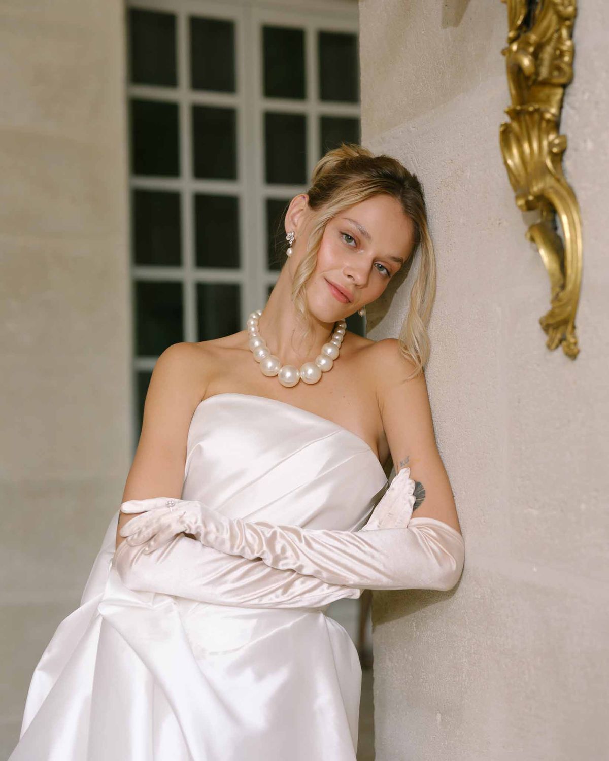 Bride wearing long satin gloves with her wedding gown