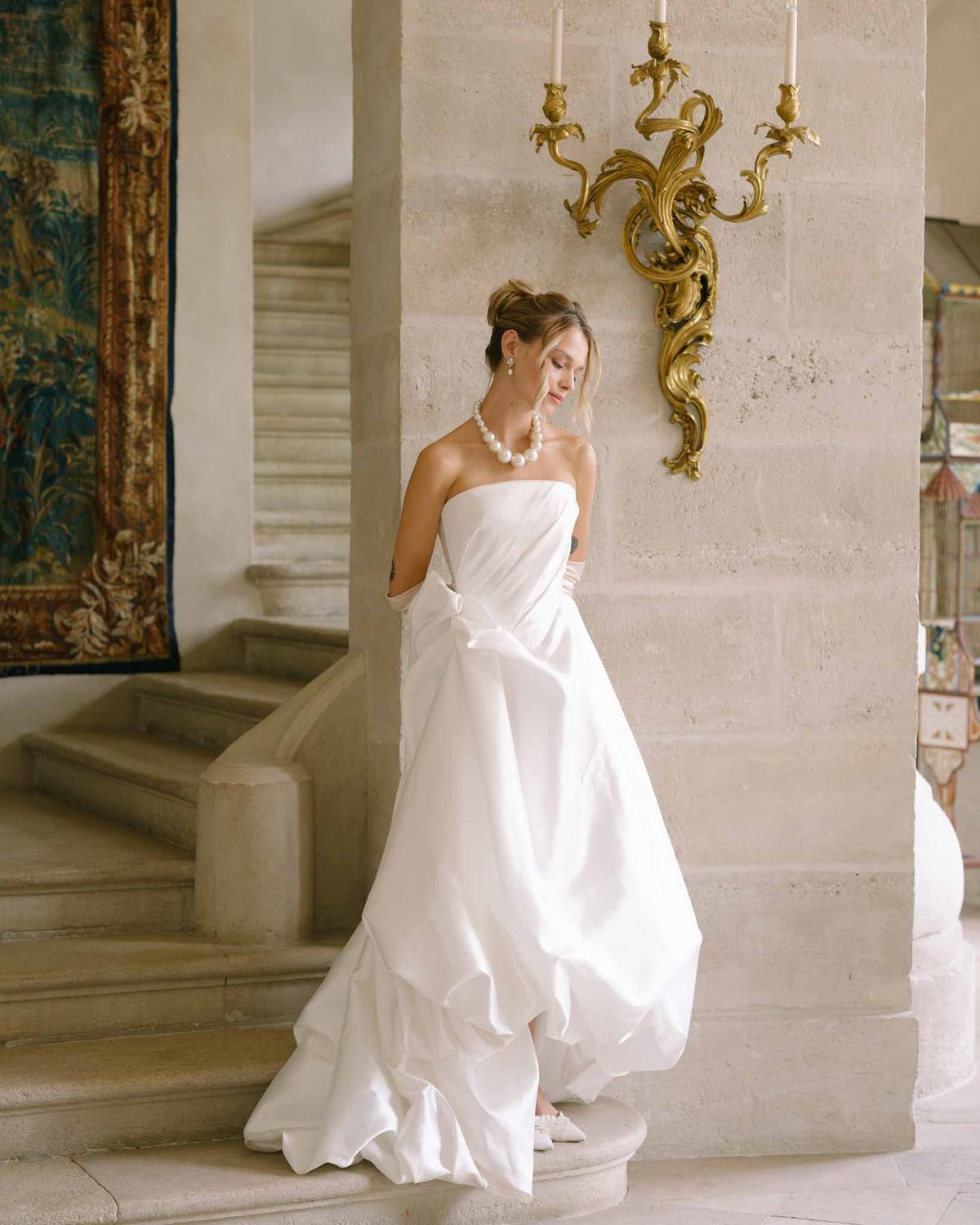 Editorial portrait of bride in strapless dress with pearl necklace
