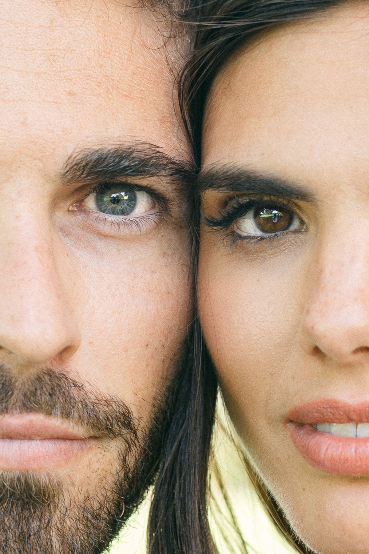 Close-up of the groom and the bride with their faces pressed together, both looking towards the camera.